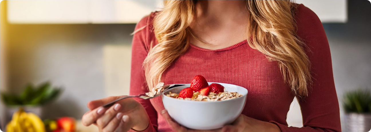 Eine Frau isst genüsslich ein Müsli.